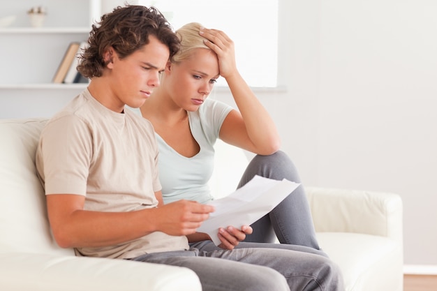 Unhappy couple holding an invoice