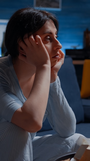 Photo unhappy, depressed, frustrated, psychotic alone woman sitting on couch feeling disappointed