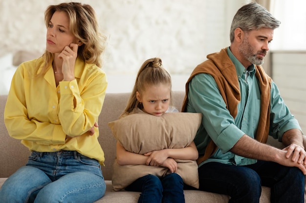 Unhappy family sitting together having problems in relationship at home