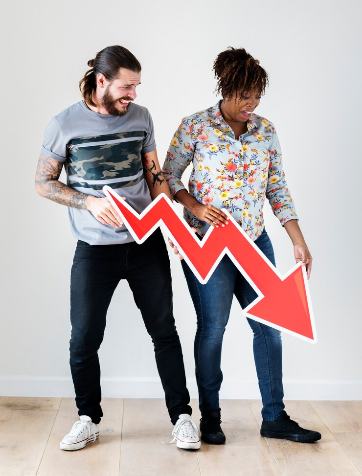 फोटो unhappy interracial couple holding a downward arrow risk and fail concept