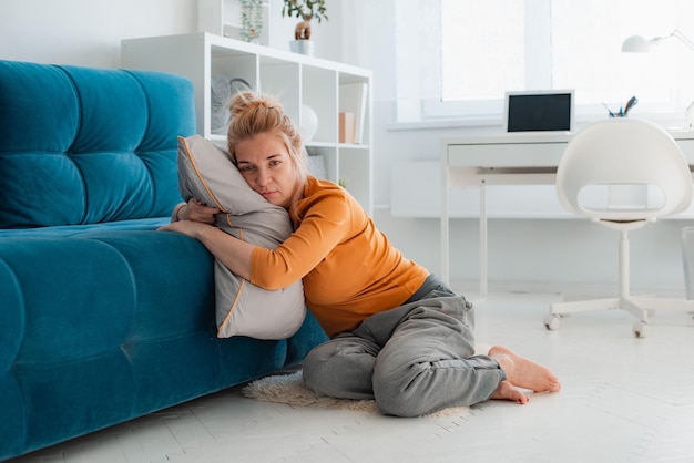 Unhappy lonely depressed woman home she sitting couch hiding her face pillow depression concept