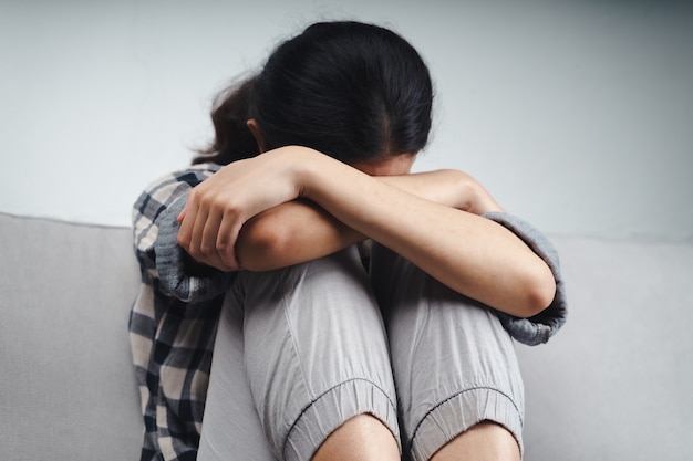 불행한 외로운 우울한 여성이 소파에 앉아 손으로 얼굴을 가리고 우울증 개념