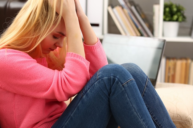 Unhappy lonely depressed woman sitting on the couch