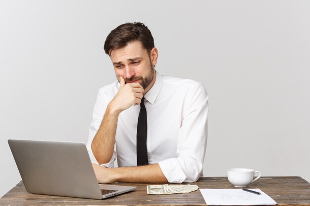 Unhappy male working in the office, looking at the camera, front view, isolated on white.