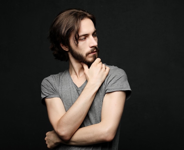 Unhappy man touching his forehead over black background