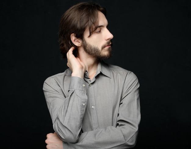 Unhappy man touching his forehead over black background