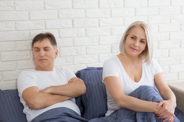 Unhappy middle aged couple has problems in relationships. Conflict in family concept. Tired from long relationship. Difficulties in sex. 