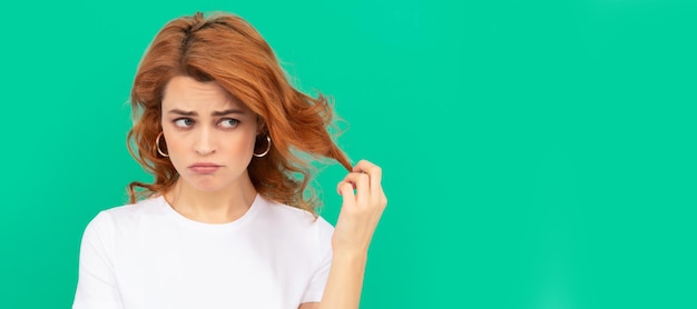 unhappy redhead woman with curly hair on blue background disappointment woman isolated face portrait banner with copy space
