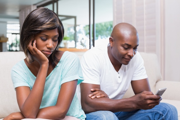 Unhappy woman watching her boyfriend texting