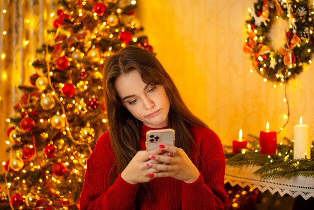 Unhappy women texting on her phone in beautiful Christmas room