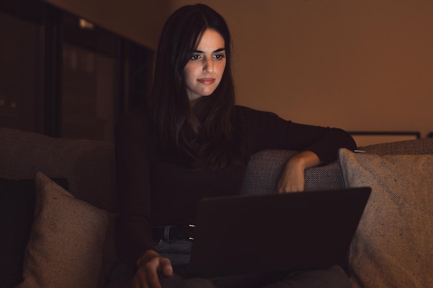 불행한 젊은 여성 노동자는 노트북 스크린을 보며 늦은 밤에 기기 고장이나 작동 문제로 충격을 받았습니다.