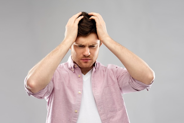 unhappy young man suffering from headache