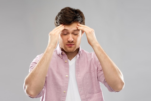 unhappy young man suffering from headache