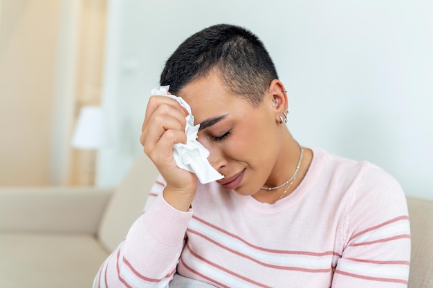 Unhappy young woman covering face with hands crying alone close\
up depressed girl sitting on couch at home health problem or\
thinking about bad relationships break up with boyfriend\
divorce