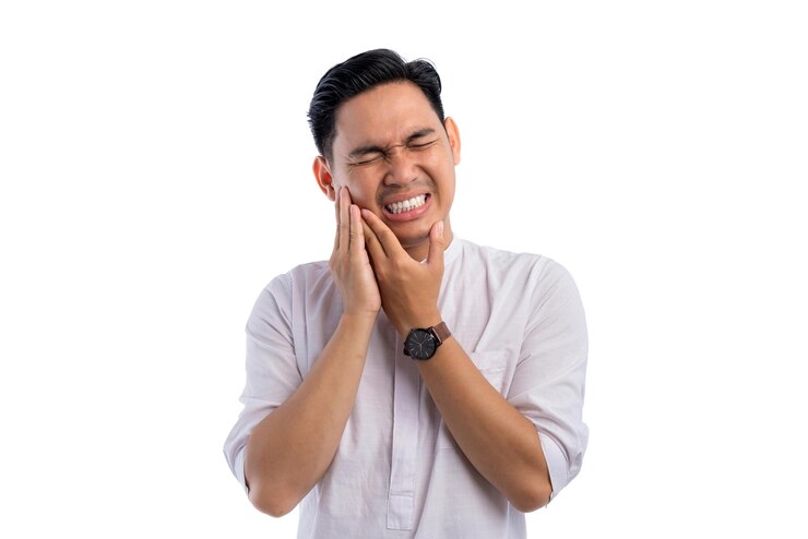 アジア系イスラム教徒の男性は急性歯痛に苦しみ痛みの表情でを触り白い背景に隔離されたラマダンとイード・フィトール祝いのコンセプト