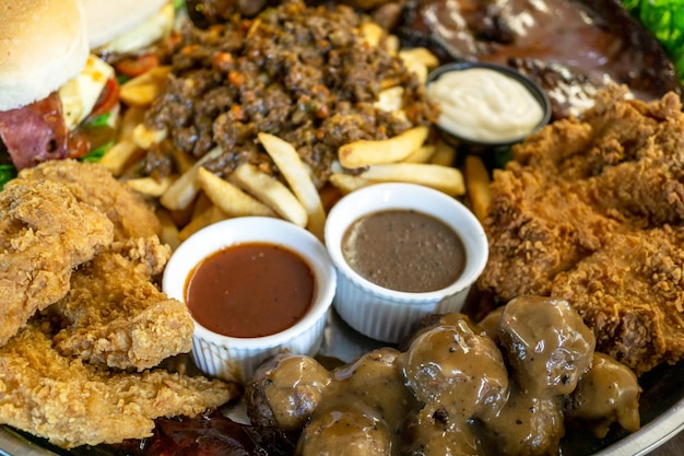 Unhealthy food steak fried chicken hamburger ham sauce black pepper french fries and meat ball