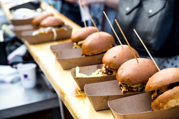 Unhealthy street food burgers with meat and cheese at an outdoor festival venue