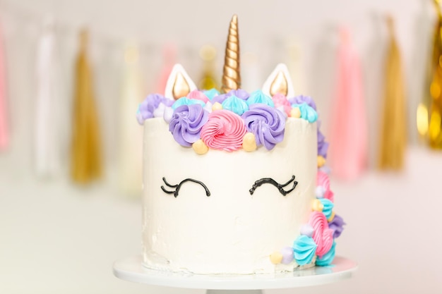 Foto torta unicorno decorata con glassa al burro multicolor.