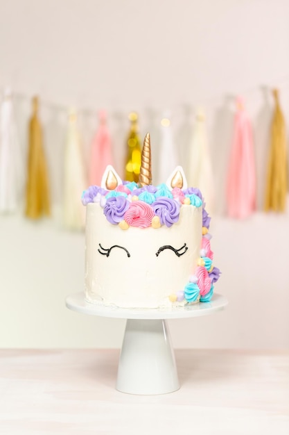 Foto torta unicorno decorata con glassa al burro multicolor.