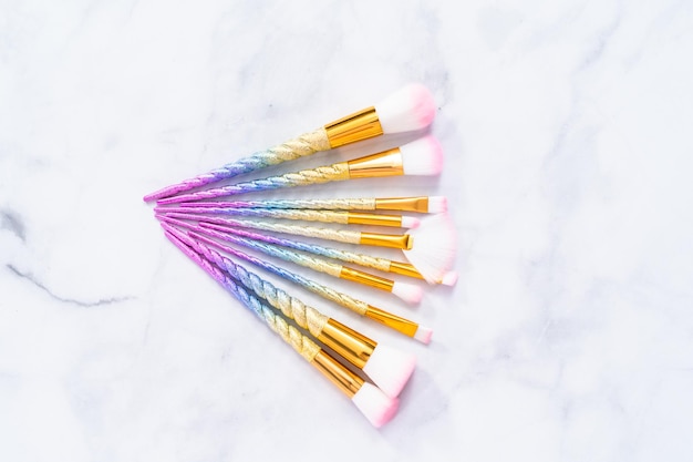 Unicorn color makeup brushes on a marble background.