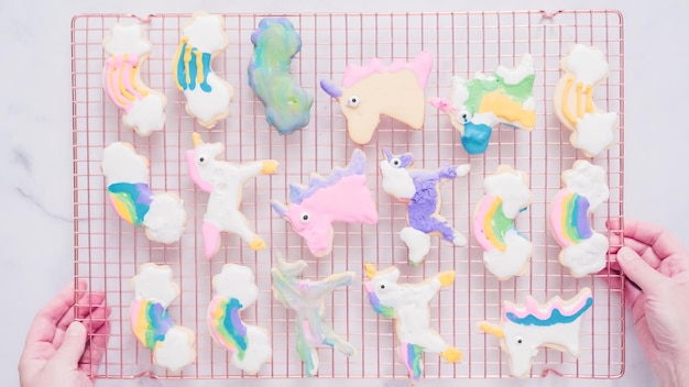 Unicorn cookies decorated with royal icing drying on drying rack.