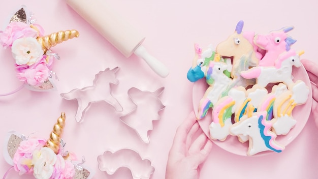 Unicorn shaped sugar cookies decorated with royal icing on pink plate.