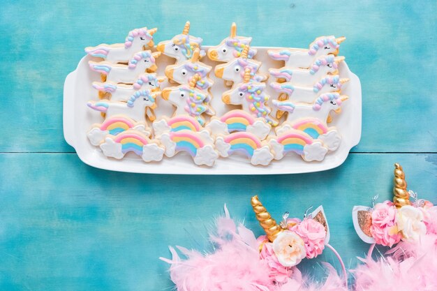 Unicorn sugar cookies decorated with royal icing on a blue background.