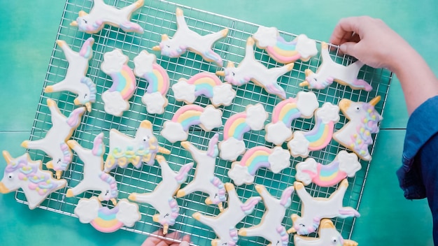 Unicorn sugar cookies decorated with royal icing on blue background.