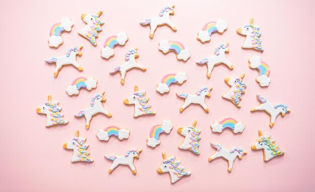 Unicorn suiker koekjes versierd met royal icing op roze achtergrond.