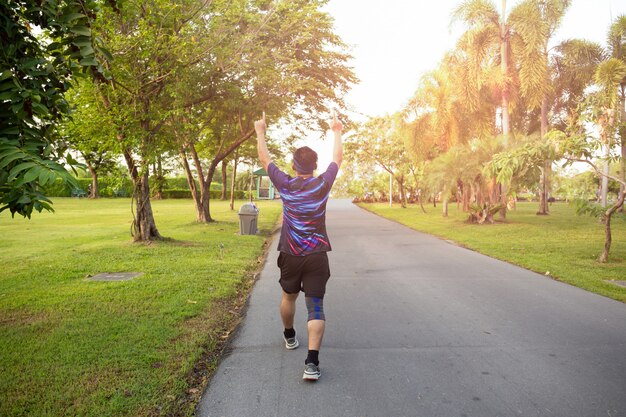 Unidendified man winner celebrating sport success raising hands up. 