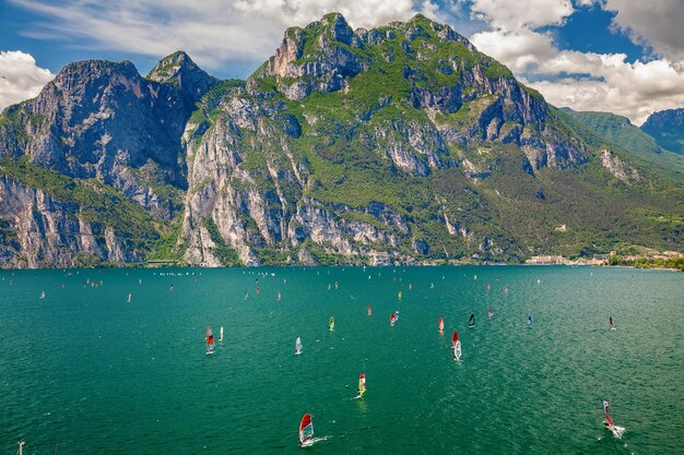 Unidentifiable windsurfers surfing on a Garda lake near Torbole and Riva del Garda, Italy