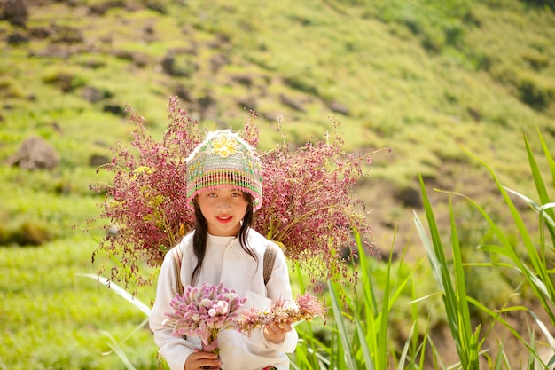 ベトナムのハギアンで菜種の花のバスケットを持つ正体不明の少数民族の子供たち。ハジャンはベトナム最北端の州です