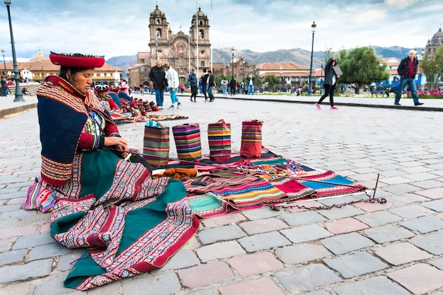 Tessitori nativi non identificati, vestiti con abiti tradizionali, dimostrano il loro artigianato. cusco.