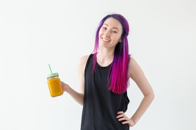 Unidentified young girl hipster holding a fruity protein juice with a straw and measuring tape