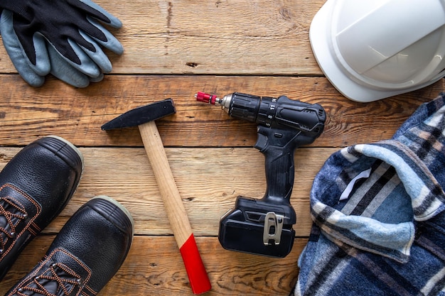 Uniform and construction tools on wooden table top view