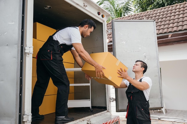 Photo uniformed employees carry out efficient unloading of cardboard boxes from the truck for customer relocation their teamwork guarantees a happy move moving day