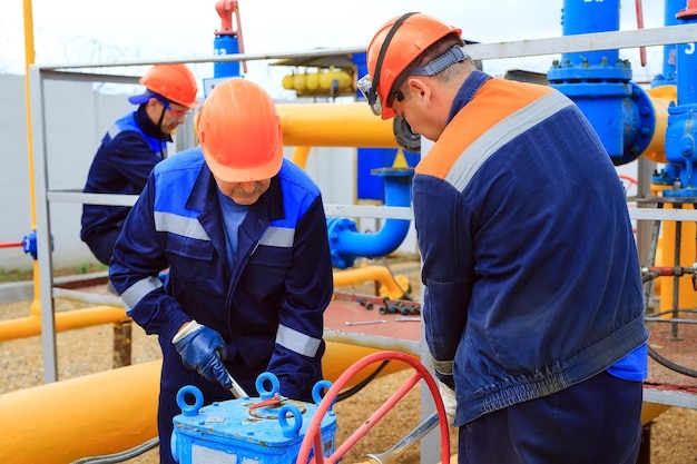 Photo a uniformed worker opens a valve to control gases