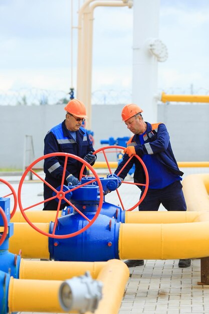 A uniformed worker opens a valve to control gases