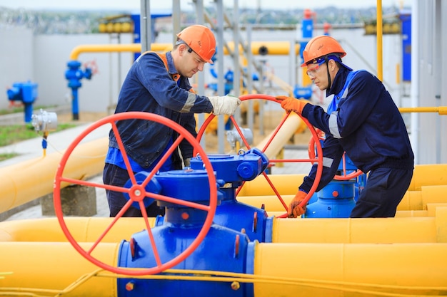 A uniformed worker opens a valve to control gases