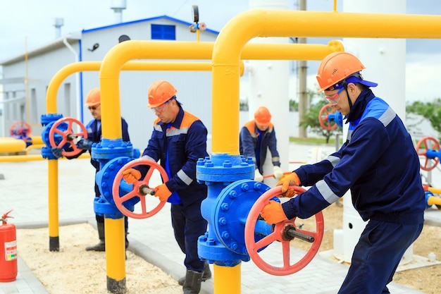 Un lavoratore in uniforme apre una valvola per controllare i gas