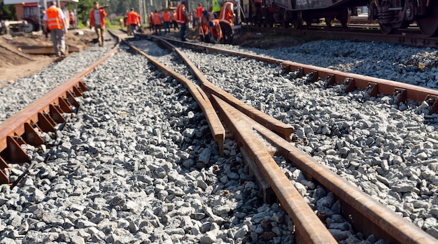 制服を着た労働者が古い鉄道路線を変更しています