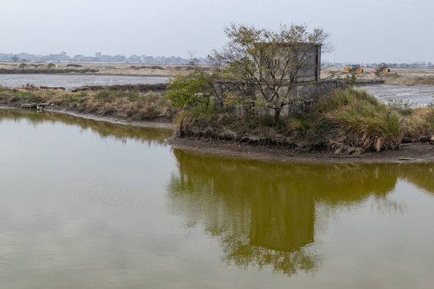 Uninhabited houseon in the sand are reflected in the water