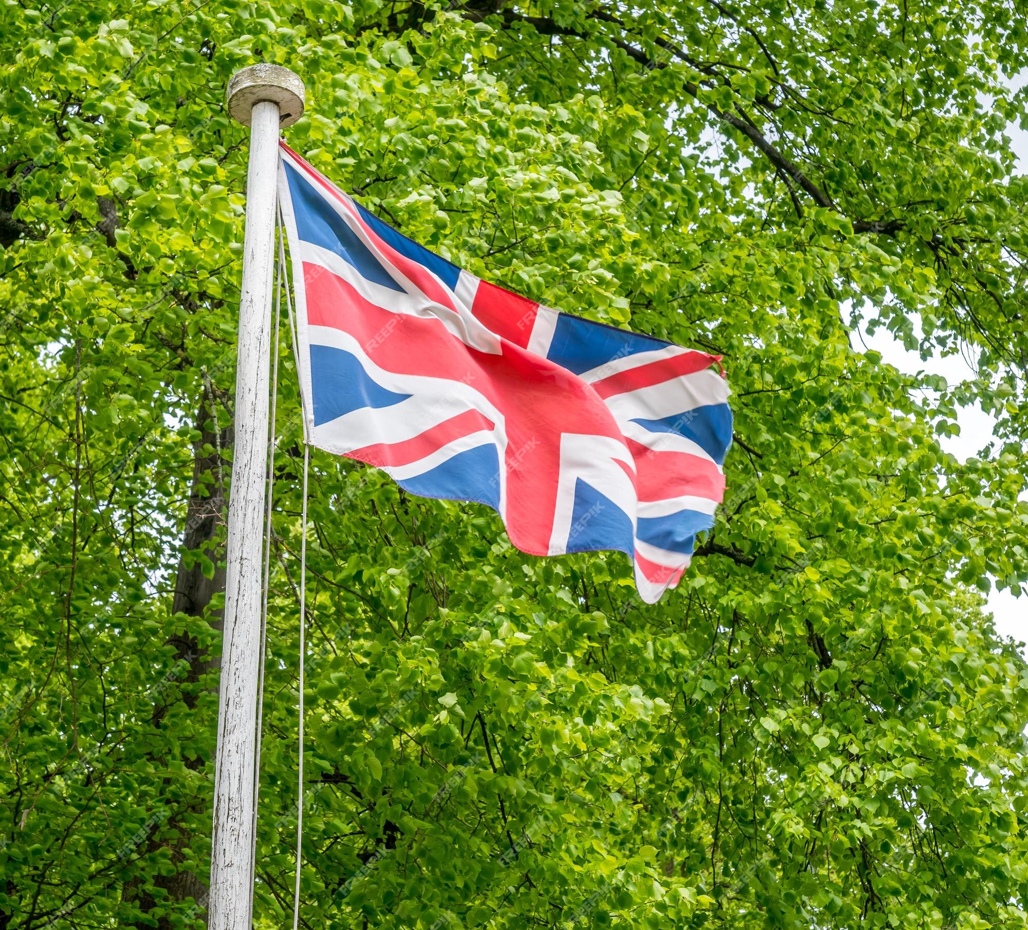 Premium Photo | Union jack flag on flagstaff in outdoor park with ...