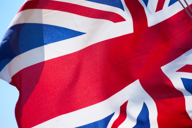 ユニオンジャック-風のクローズアップで手を振っているイギリスの旗
