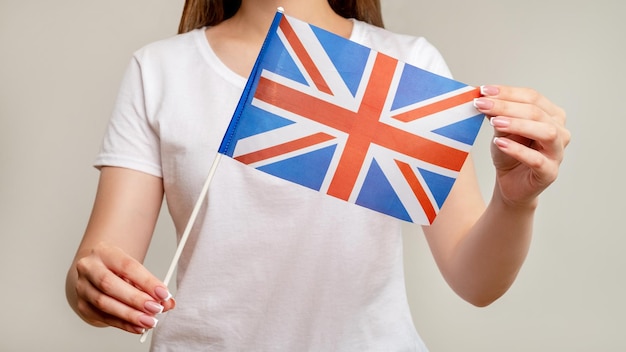 Union Jack United Kingdom Woman holding British flag with red cross on white blue isolated on blur neutral background Official national symbol of UK Great Britain