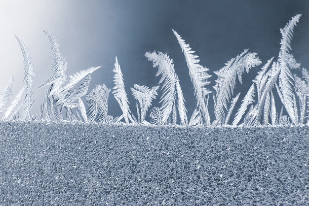 Foto i modelli unici del ghiaccio sul vetro della finestra. trame e sfondi naturali