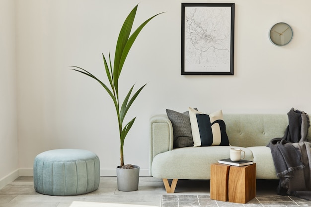 Unique loft interior with green comfortable sofa, design furniture, mock up poster map, carpet, plants, decoration and elegant accessories. Modern home decor in living room. White wall. Template.