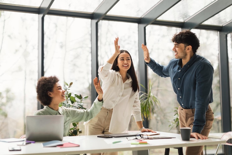 Photo united business team giving high five celebrating success in office