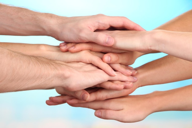 United hands on bright background Conceptual photo of teamwork