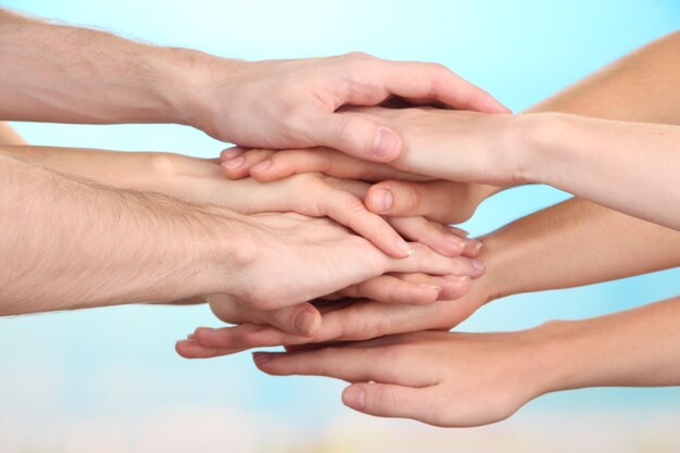 United hands on bright background Conceptual photo of teamwork